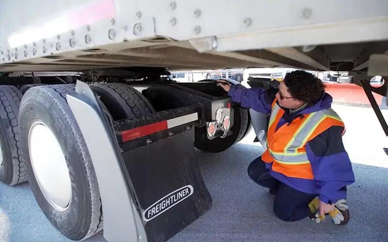 Close-up of flatbed trailer brake drum and lining inspection in progress