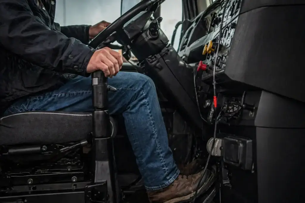 driver inside modern semi truck cab with transmission selector highlighting manual vs automated transmission decision for fleet operations